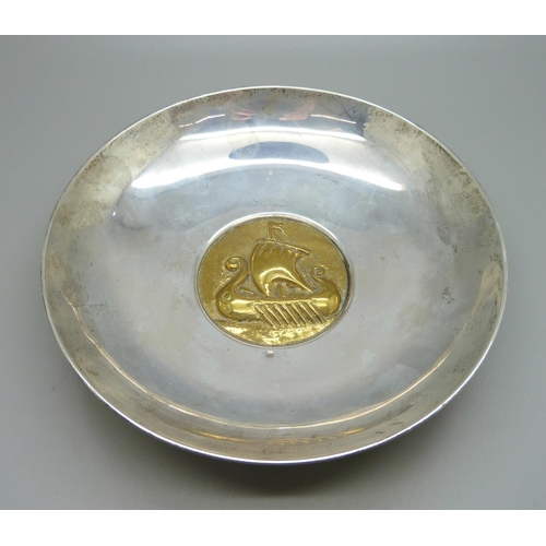 805 - A white metal bowl marked 925, with brass insert depicting a Viking ship, 18cm