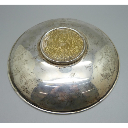 805 - A white metal bowl marked 925, with brass insert depicting a Viking ship, 18cm