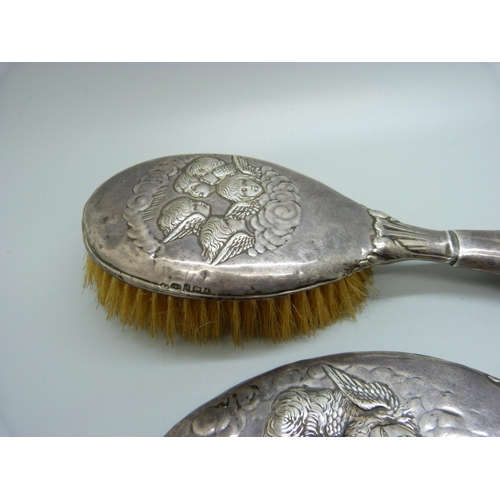 819 - Two silver backed brushes decorated with Reynolds angels, a/f