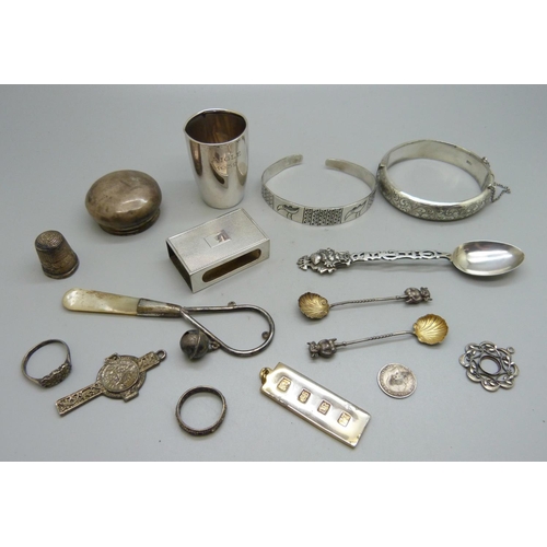 845 - Two silver bangles, a pair of silver Lincoln Imp salt spoons, a silver matchbox case, a silver shot,... 