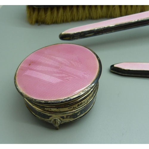 871 - A silver and pink enamel hand mirror, two brushes and a trinket pot, a/f