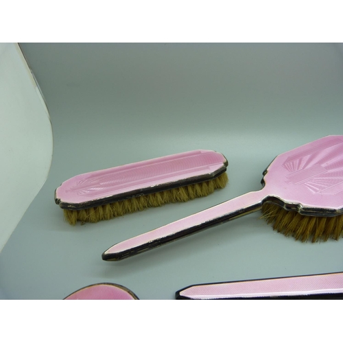 871 - A silver and pink enamel hand mirror, two brushes and a trinket pot, a/f