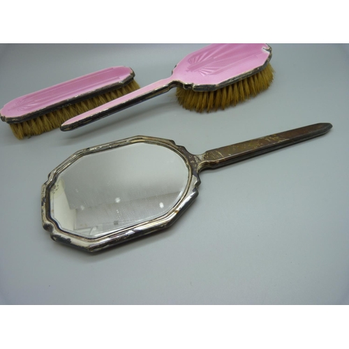 871 - A silver and pink enamel hand mirror, two brushes and a trinket pot, a/f