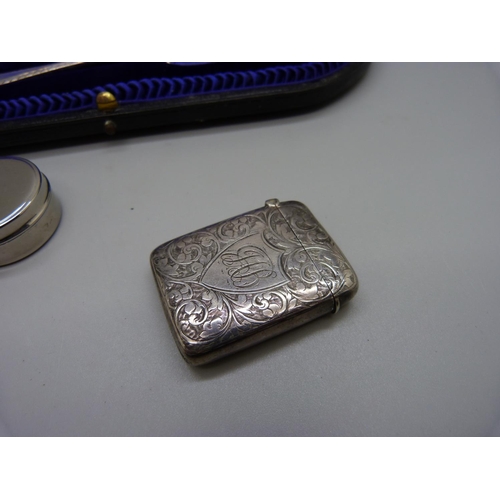 878 - A cased silver christening set, London 1907, a silver vesta case, Birmingham 1895, 76g, and modern p... 