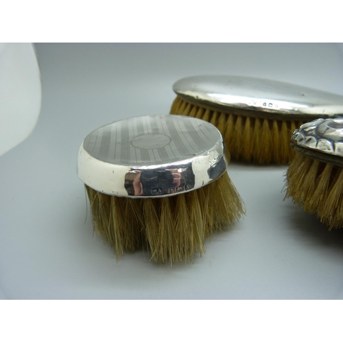 880 - Three silver backed brushes, a/f