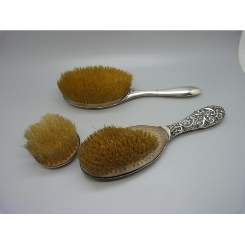 880 - Three silver backed brushes, a/f