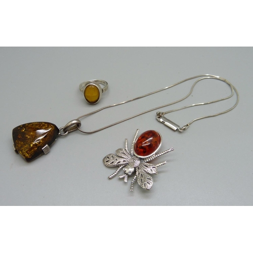 994 - A silver and amber ring, N, a silver brooch and a silver mounted pendant and chain