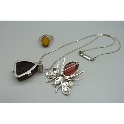 994 - A silver and amber ring, N, a silver brooch and a silver mounted pendant and chain