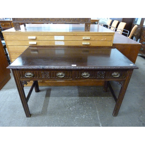 119 - A Chippendale Revival carved mahogany two drawer writing table