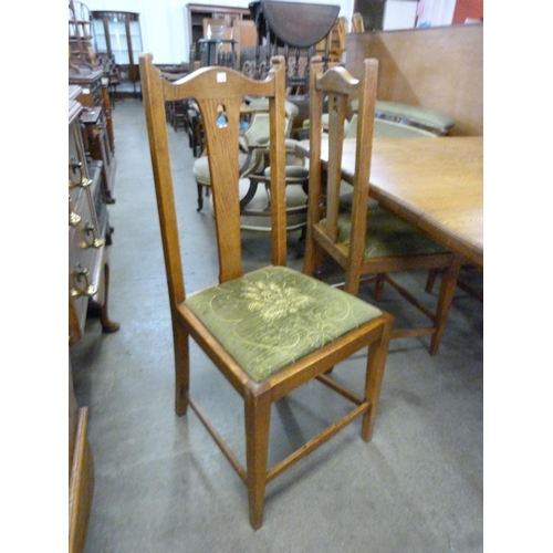 142 - A Victorian oak dining table, a set of four Arts and Crafts dining chairs and a sideboard