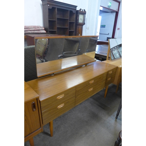 214 - A simulated teak sideboard, a chest of drawers and dressing table