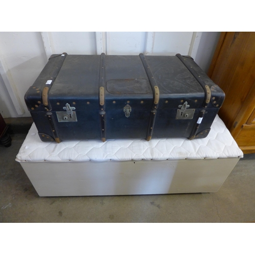 243 - An early 20th Century steamer trunk and a painted ottoman