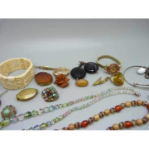 857 - Costume jewellery, including a Bakelite brooch and glass beads