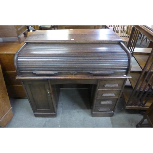 114 - An early 20th Century oak tambour roll top desk