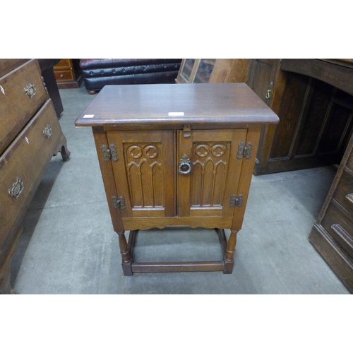 115 - A small carved oak cupboard