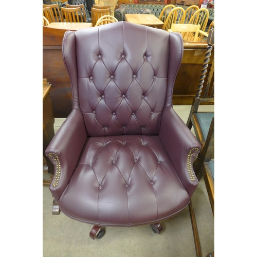 118 - A mahogany and burgundy leather revolving desk chair