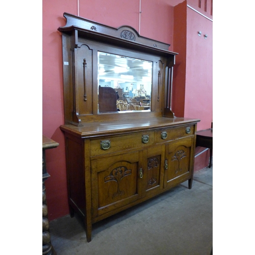 22 - An Arts and Crafts carved oak mirrorback sideboard