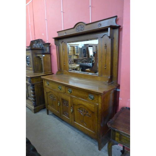 22 - An Arts and Crafts carved oak mirrorback sideboard