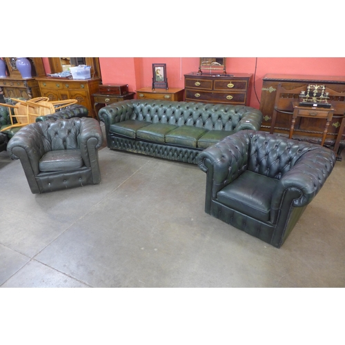 26 - A green leather Chesterfield three piece suite, comprising; four seater settee and two club chairs