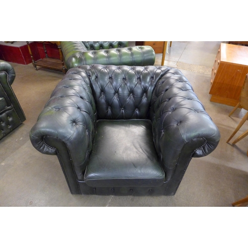 26 - A green leather Chesterfield three piece suite, comprising; four seater settee and two club chairs