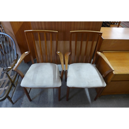 91 - A pair of teak elbow chairs