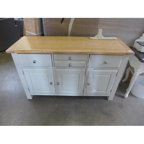 1562 - An ivory and oak three drawer three door sideboard, slight damage underneath