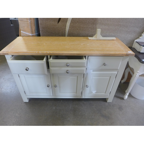 1562 - An ivory and oak three drawer three door sideboard, slight damage underneath