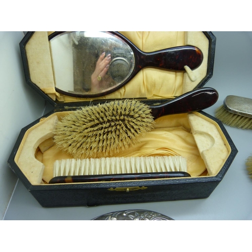 779 - A xylonite faux tortoiseshell vanity set, boxed, and three silver dressing table items, two brushes ... 