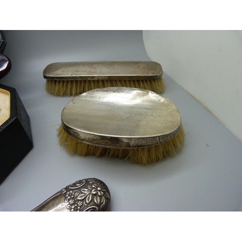 779 - A xylonite faux tortoiseshell vanity set, boxed, and three silver dressing table items, two brushes ... 