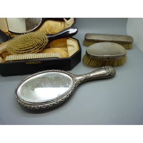 779 - A xylonite faux tortoiseshell vanity set, boxed, and three silver dressing table items, two brushes ... 