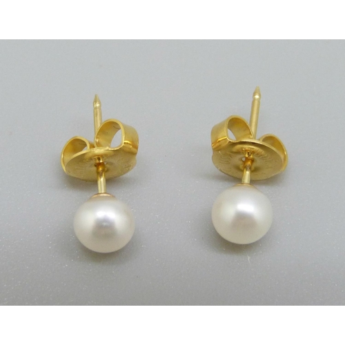 863 - A pair of 18ct gold and pearl stud earrings, (fasteners not marked 18ct)