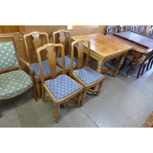 135 - A walnut draw-leaf table and four chairs