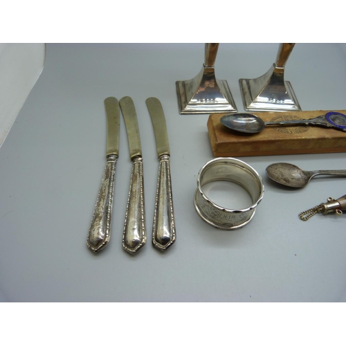 834 - A pair of silver candlesticks, a silver napkin ring, two silver spoons, a metal and horn scent bottl... 