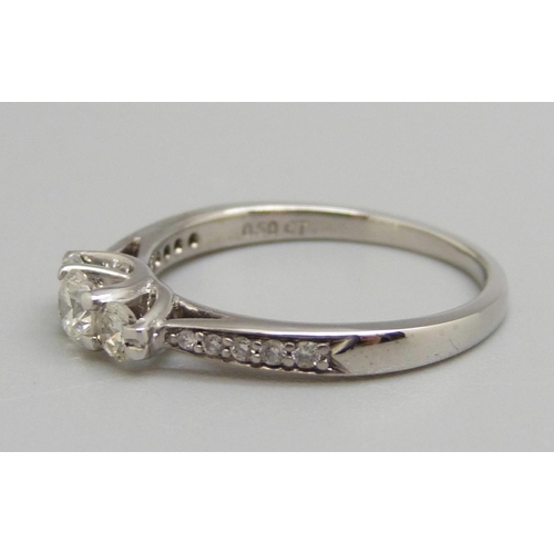 965 - An 18ct white gold three stone diamond ring with diamond shoulders, N, 2.9g, shank marked 0.50ct