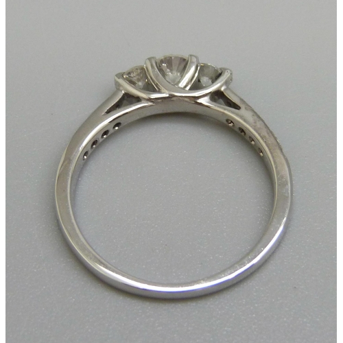 965 - An 18ct white gold three stone diamond ring with diamond shoulders, N, 2.9g, shank marked 0.50ct