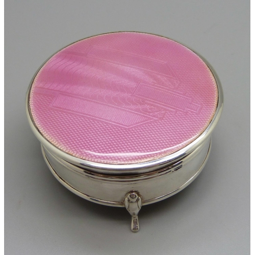 969 - A silver Art Deco trinket box with a pink enamel top, (marks worn), 61mm diameter