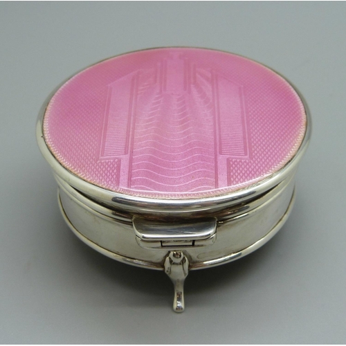 969 - A silver Art Deco trinket box with a pink enamel top, (marks worn), 61mm diameter