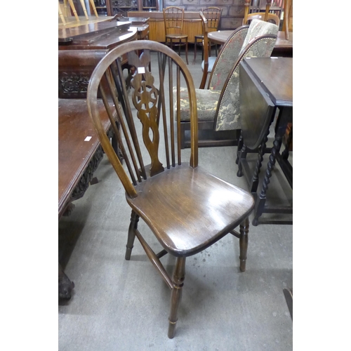 125 - An oak draw leaf refectory table and four beech wheelback chairs