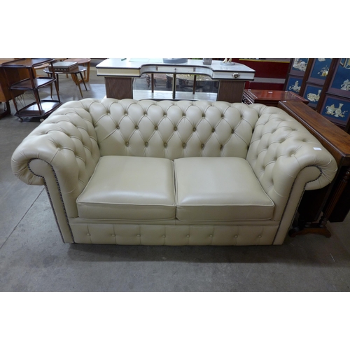 15 - A cream leather Chesterfield settee