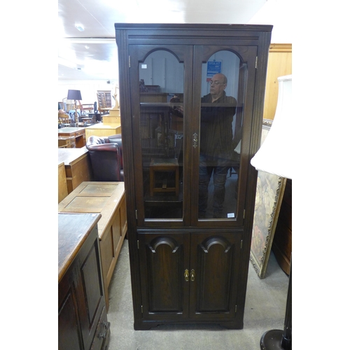 223 - An oak freestanding corner cabinet, a standard lamp, small bookcase, etc. (4)