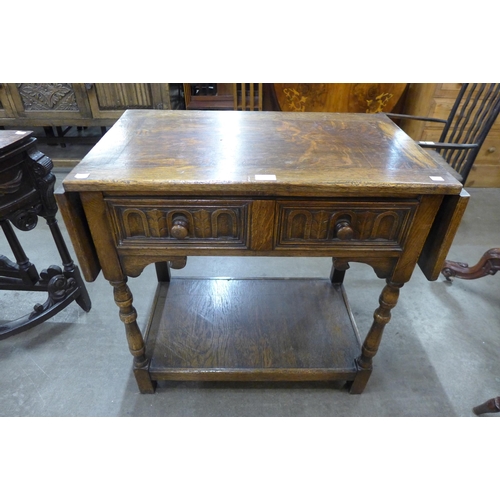 33 - A 17th Century style carved Ipswich oak single drawer drop leaf side table