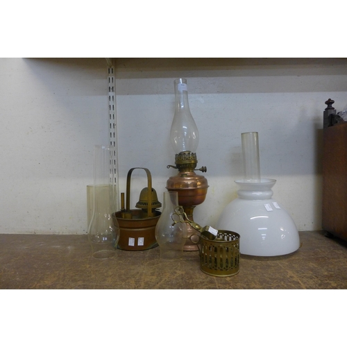 353 - A copper oil lamp, assorted oil lamp chimneys, etc.