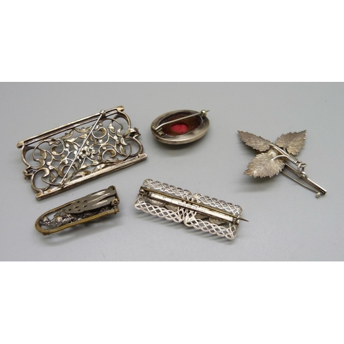 1029 - Two silver brooches, a marcasite and pearl set brooch/pendant, an oval memorial brooch, a/f and a cl... 