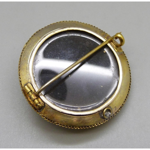 1032 - A yellow metal memorial brooch, set with pyrope garnets, 35mm