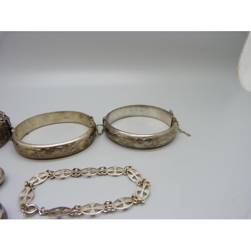 1096 - Three silver bangles, a Victorian silver ring, S, a silver rattle, a/f, and a silver bracelet, 81g