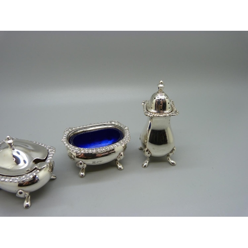 853 - A three piece silver cruet set with a spoon, 138g