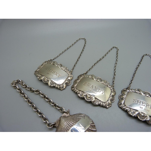 866 - A set of three silver bottle labels, a silver Gin bottle label and a silver bracelet, 106g