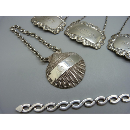 866 - A set of three silver bottle labels, a silver Gin bottle label and a silver bracelet, 106g