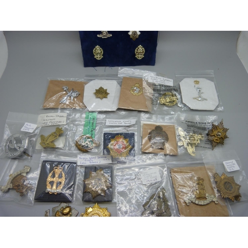 929 - Twenty assorted Regimental cap badges and a board of miniatures