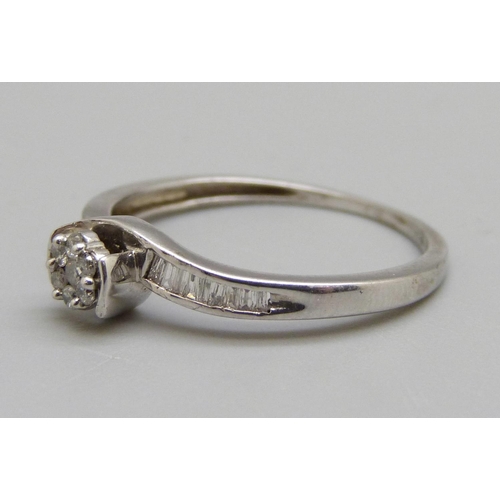 955 - A silver ring set with seven brilliant cut diamonds and eighteen baguette cut diamonds, S